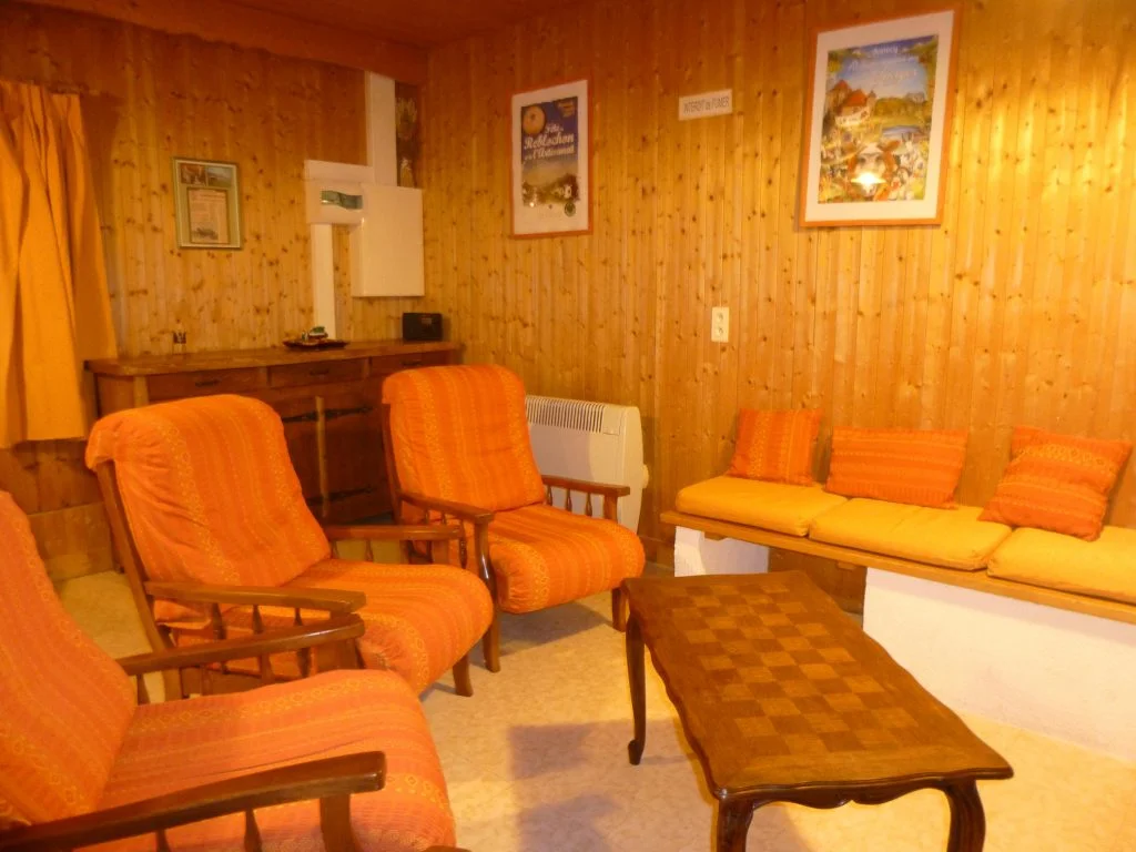 Coin salon avec cheminée et banquette du gîte Les Augets